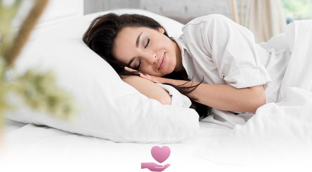 Woman sleeping peacefully in white bed linen, illustrating overnight wear during the first days after surgery