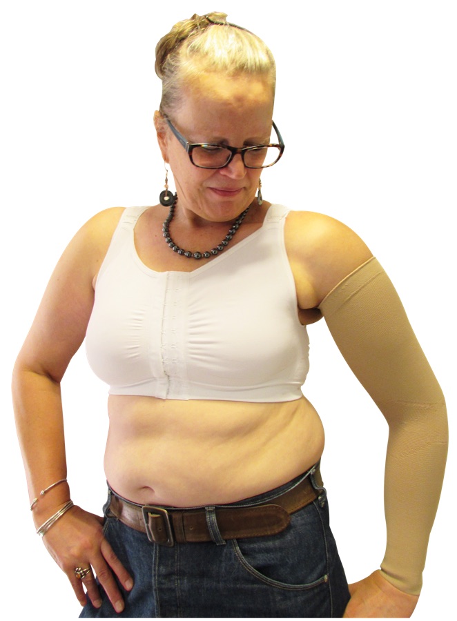 Woman wearing the white Reco Bra with a compression sleeve on her left arm, showing the fit on a fuller figure